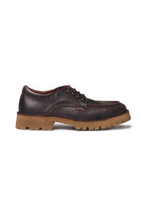 Chaussure à lacets en cuir brun foncé texturé avec une semelle épaisse en caoutchouc fauve à crampons, coutures visibles et talon bas, présentée en profil latéral sur fond blanc.