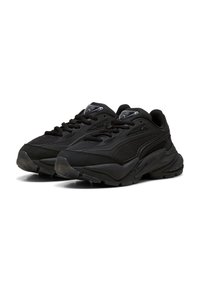 Un paio di scarpe da ginnastica nere con tomaia in mesh e materiali sintetici, suola spessa e imbottita, e chiusura con lacci, angolate per mostrare la vista frontale e laterale.
