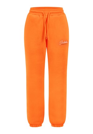 Pantaloni della tuta arancioni brillanti realizzati in un tessuto morbido, con vita regolabile con cordino, polsini elastici e un piccolo logo ricamato sul lato.