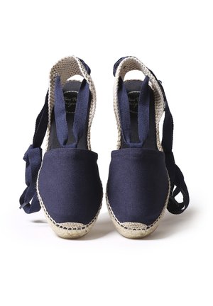 Marineblå canvas espadrilles med fletede jutesåler og ankelbindinger, der har et fladt design og rund tå. Tekstureret overflade med naturlige accenter.