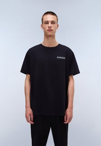 Black cotton t-shirt with a crew neck and short sleeves. Features a small white graphic logo on the left chest. Simple, relaxed fit.