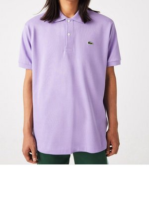 Liliowa koszulka polo z kołnierzykiem, krótkimi rękawami i trzema guzikami. Posiada małe zielone haftowane logo. Gładka, lekka tkanina.