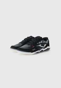 Black athletic shoes with a leather and mesh upper, featuring a textured pattern, white sole, and contrasting logo accents.