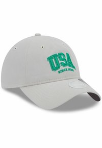 Gorra de béisbol beige con el bordado verde "USA" y "Desde 1920". Presenta un visera curva y agujeros de ventilación en la parte superior.