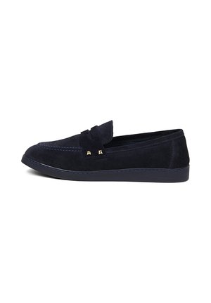 Navyblauwe suède loafer met decoratieve band, contrasterende stiksels en platte rubberen zool, zijaanzicht op witte achtergrond.