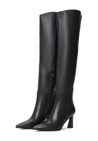 Botas negras hasta la rodilla hechas de cuero suave con puntas afiladas y un tacón delgado. Cuentan con un cierre lateral con cremallera.