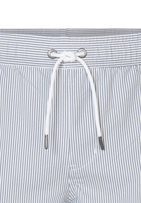 Bañador a rayas en azul y blanco, con una cintura ajustable con cordón y ojales de metal plateados, además de una textura suave.