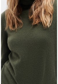 Maglione a collo alto verde oliva con una trama morbida, caratterizzato da una silhouette aderente e colletto a coste.