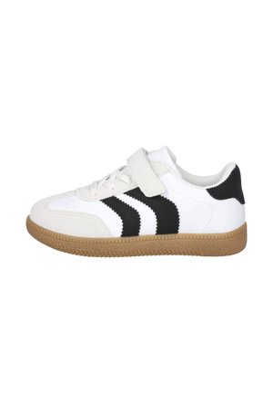 Zapatilla blanca con suela marrón, rayas negras en zigzag en los lados, cordones blancos y una cinta de velcro blanca, mostrada desde el lado exterior.