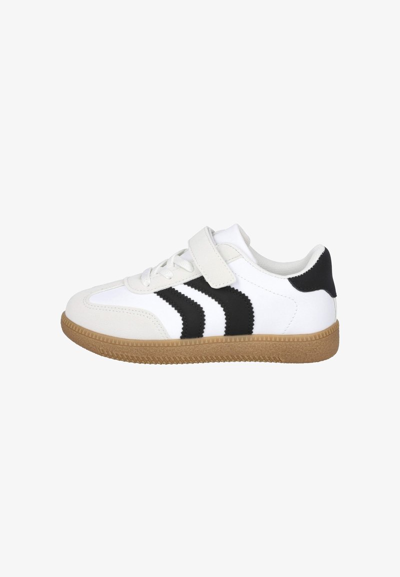 Zapatilla blanca con suela marrón, rayas negras en zigzag en los lados, cordones blancos y una cinta de velcro blanca, mostrada desde el lado exterior.