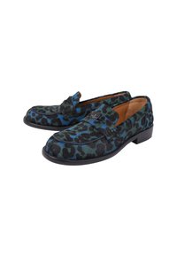 Lauwappige loafers in blauwtinten en zwart, gemaakt van textuurmateriaal met een platte zool en een decoratieve band over de voorkant.
