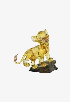 Kristallfigur eines lächelnden Lions, durchscheinend gelb mit detaillierten Facetten und einem braunen Sockel, der wie ein Stein aussieht. Akzente umfassen große Augen und Ohren.