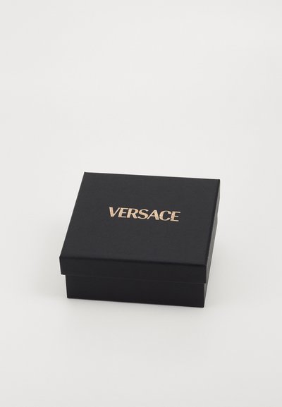 Schwarze Geschenkbox mit matter Textur und goldenen "VERSACE"-Logo auf dem Deckel. Quadratische Form, robuste Konstruktion.