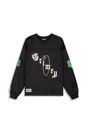 Black long-sleeve shirt with mesh texture, featuring white "Grimey" text and a yellow circle accent. Green clover patches on sleeves.