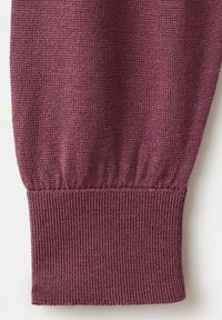 Prim-plan cu mâneca unui pulover tricotat în culoarea mauve, cu manșetă cu rebroderie și un model texturat de cusături.