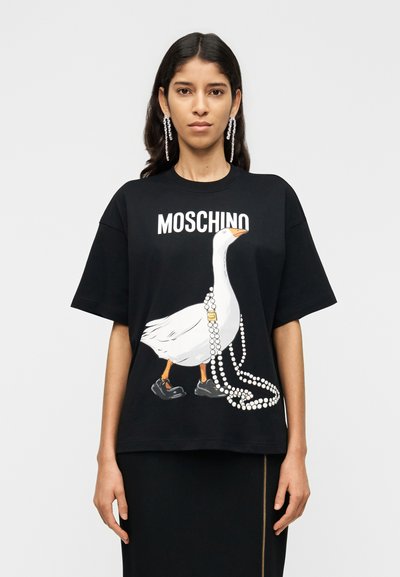 Black cotton t-shirt with a loose fit, featuring a graphic of a goose wearing shoes and holding a string of pearls, with "MOSCHINO" text above.