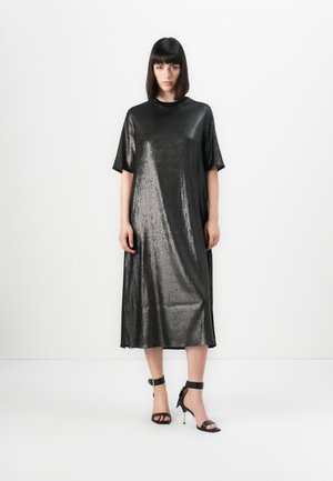 Abito midi metallico nero con maniche corte e scollatura rotonda. Texture morbida e leggera lucentezza, abbinato a tacchi neri con cinturino alla caviglia.