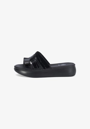Sandale noire à bout ouvert avec larges brides brillantes et semelle épaisse et profilée pour plus de hauteur et de confort.