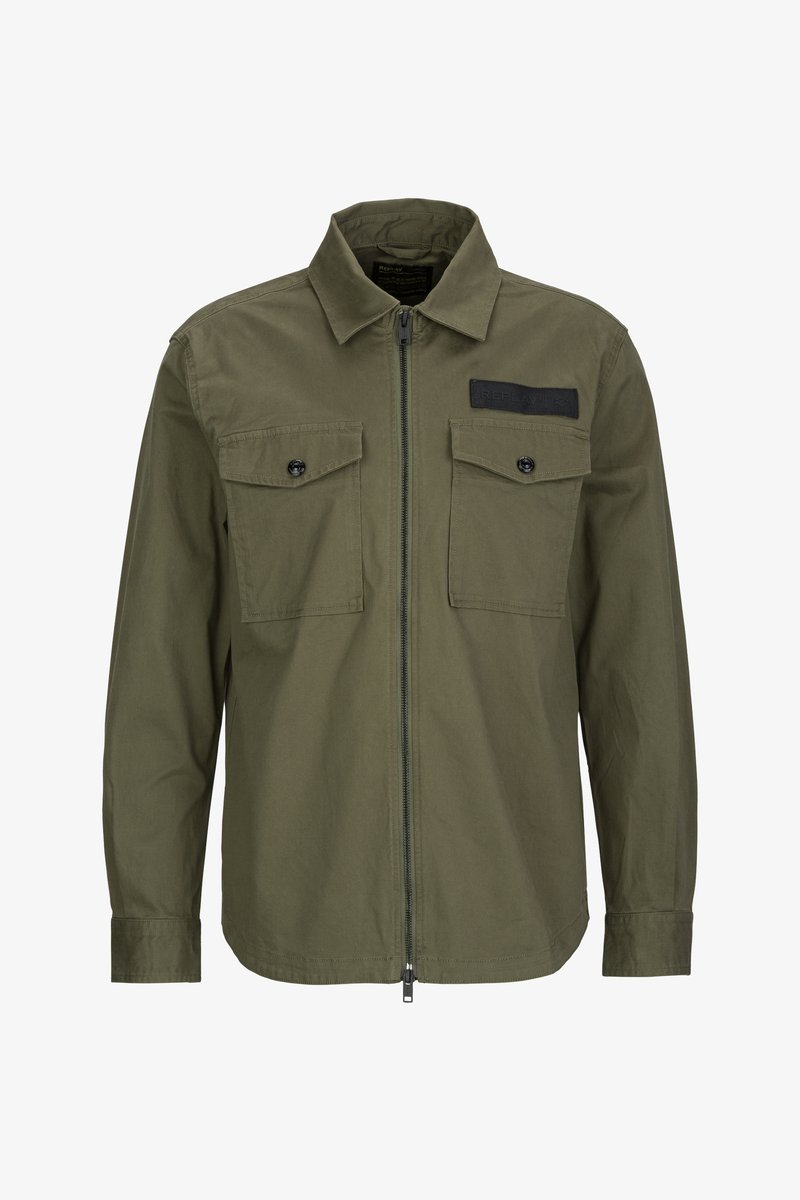 Olivgrün Jacke aus Baumwolle mit einem Reißverschluss vorne, zwei Brusttaschen mit Klappen und einem schwarzen Stoffakzent oben links.
