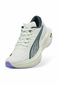 Witte sportieve schoen met een gestructureerde bovenkant, donkergroene accenten en een paarse zool; heeft een vetersluiting en logo-details.