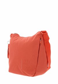 Sac bandoulière en tissu orange avec surface texturée, fermeture éclair, sangle ajustable et logo de la marque en relief sur le côté.
