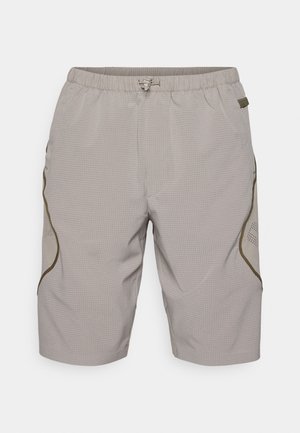 Beige shorts with a textured pattern, elastic waistband, drawstring, and side accents. Features mesh panels for breathability.