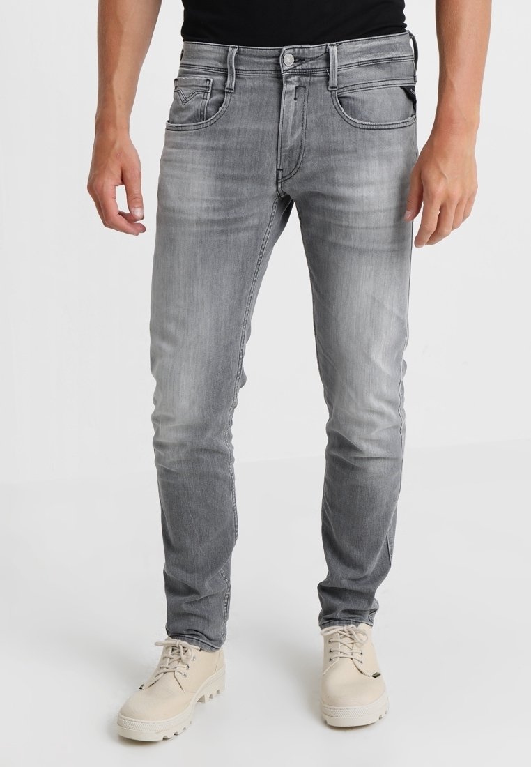 Grå denimjeans med slim fit, femficksdesign, subtil blekning och kontrasterande sömmar. Matchas med beige skor.