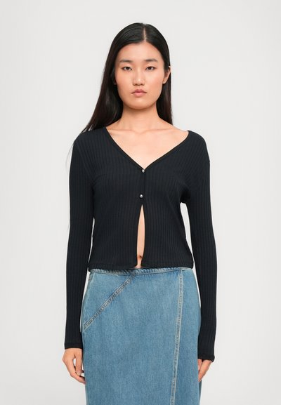 Černý žebrovaný cardigan s dlouhými rukávy, s hlubokým výstřihem do V a zapínáním na knoflíky. Textura je hladká a pružná.