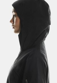 Czarna, wodoodporna kurtka z wysokim kołnierzem i dopasowanym kapturem, charakteryzująca się gładką teksturą i minimalistycznym designem. Widoczne są zamykane na zamek kieszenie po bokach.
