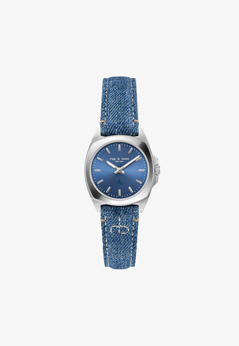 Blue denim strap watch with a stainless steel case. The blue dial features silver hour markers and hands, with brand logo at 12 o'clock.