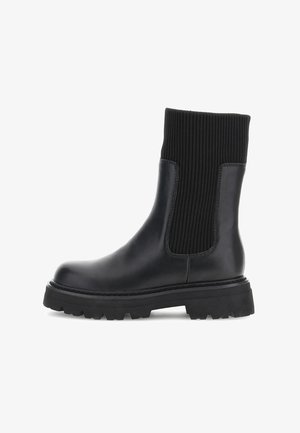 Cizme negre de gleznă cu un corp din piele netedă și partea superioară din textil nervurat. Prezintă o talpă groasă din cauciuc pentru aderență și stabilitate.