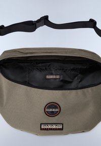 Khaki budväska med en svart dragkedja, vadderad inredning och tyglogopatchar. Har en justerbar svart axelrem.