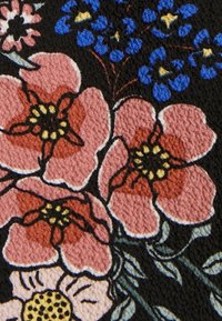 Gros plan sur un tissu avec des fleurs roses et bleues texturées, des feuilles vertes, et un fond noir.