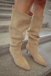 Beesuvad kuni põlvedeni ulatuvad saapad pehmest suede'ist, kergelt voldiva disainiga ja terava varbaga, õhukese stilettokontsaga.