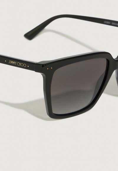 Fekete négyzet alakú napszemüveg gradient szürke lencsékkel. Arany "JIMMY CHOO" logóval és kis dísztűkkel a kereten.
