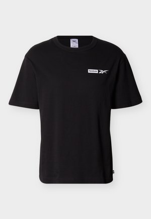 Sort kortermet Reebok-t-skjorte med rund hals og liten hvit logo på venstre bryst mot ensfarget bakgrunn.