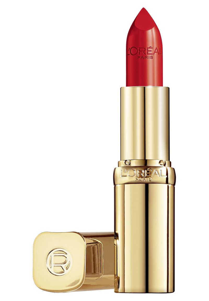 Rode lippenstift in een gouden metalen behuizing met een puntige tip en een gegraveerde merknaam. De dop heeft een cirkelvormig logo. Compacte formaat voor eenvoudige hantering.