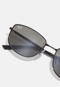 Ochelari de soare Ray-Ban cu un cadru metalic elegant, negru, lentile întunecate cu degradé și suporturi pentru nas transparente pentru un plus de confort.