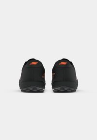 Black athletic shoes with a smooth surface, orange accents, padded collar, and a rugged sole designed for traction.
