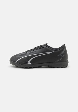 Schwarze Sportschuhe mit einem strukturierten synthetischen Obermaterial, ausgestattet mit grauen diagonalen Streifen, einem flachen Design und einer Gummisohle für besseren Grip.