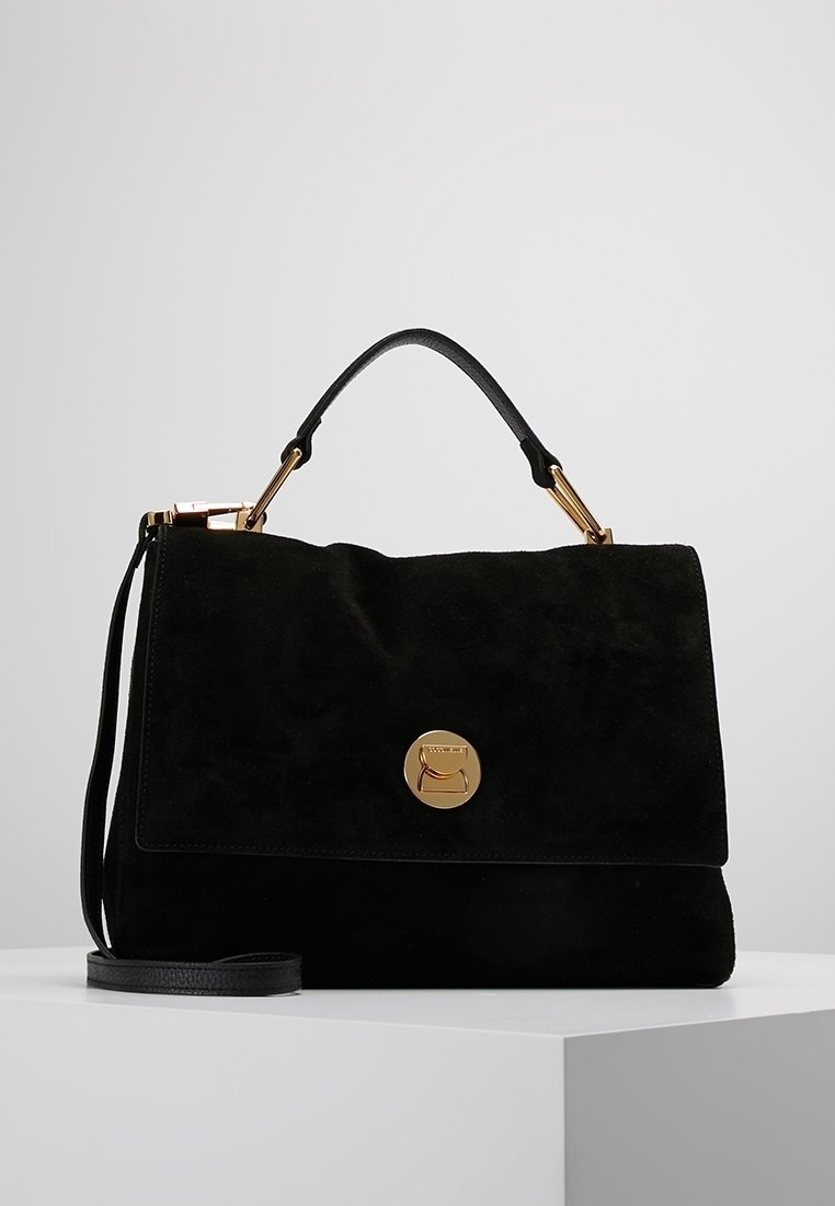 Czarna zamszowa torebka z klapką, złotymi okuciami i odpinanym paskiem na ramię. Na przedzie znajduje się okrągłe logo.