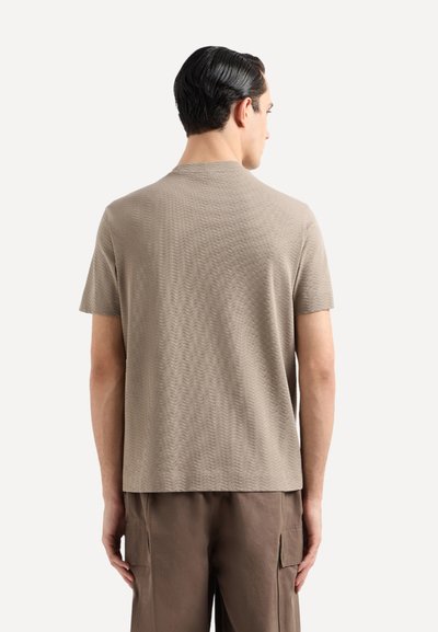 T-shirt corto a maniche corte color marrone chiaro con un motivo a zigzag testurizzato, dotato di scollatura a girocollo e vestibilità rilassata.