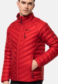 Rote isolierte Jacke mit Reißverschluss vorne, Chevron-Steppmuster, hohem Kragen und zwei Reißverschlusstaschen; mit Markenlogo auf der Brust.