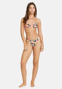 Bikini set s květinovým vzorem v růžové, oranžové a žluté barvě na černém pozadí. Vrchní část má tenké ramínka a tvarované košíčky.