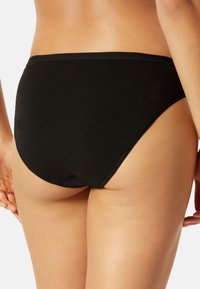 Schwarzes Baumwoll-Bikiniunterteil mit glatter Textur, hohen Beinausschnitten und einem breiten Bund, entworfen für vollständige Abdeckung und Komfort.