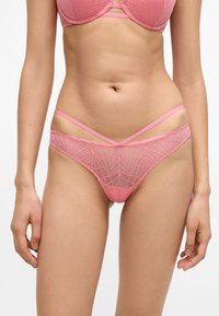 Ροζ δαντελένια εσώρουχα με γεωμετρικό μοτίβο, με κυματιστές άκρες και λεπτές τιράντες. Μαλακή, διαφανής υφή, σχεδιασμένη για άνεση.