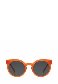 Lunettes de soleil rondes avec une monture translucide orange et des verres gris foncé. Présentent des branches épaisses et un design audacieux et moderne.