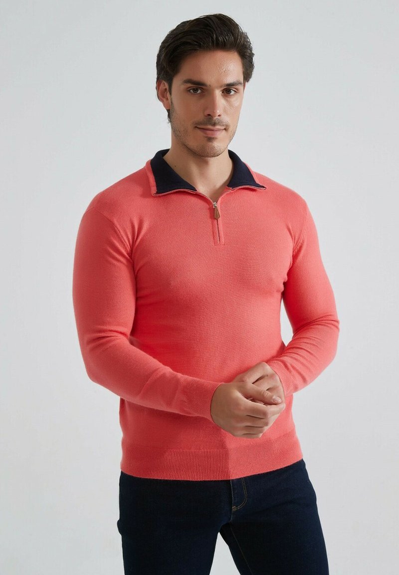 Pull en maille corail avec un col navy, fermeture à demi-zip, manches longues, coupe ajustée et poignets et ourlet côtelés.