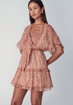 Floral print dress in light orange and beige, with short flutter sleeves, a wrap front, and a tiered ruffled hem. Semi-sheer fabric texture.