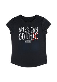 Černé tričko s krátkým rukávem a bílým nápisem "AMERICAN GOTHIC" se červeným X přes "C" a menším textem "WEDNESDAY" pod ním.